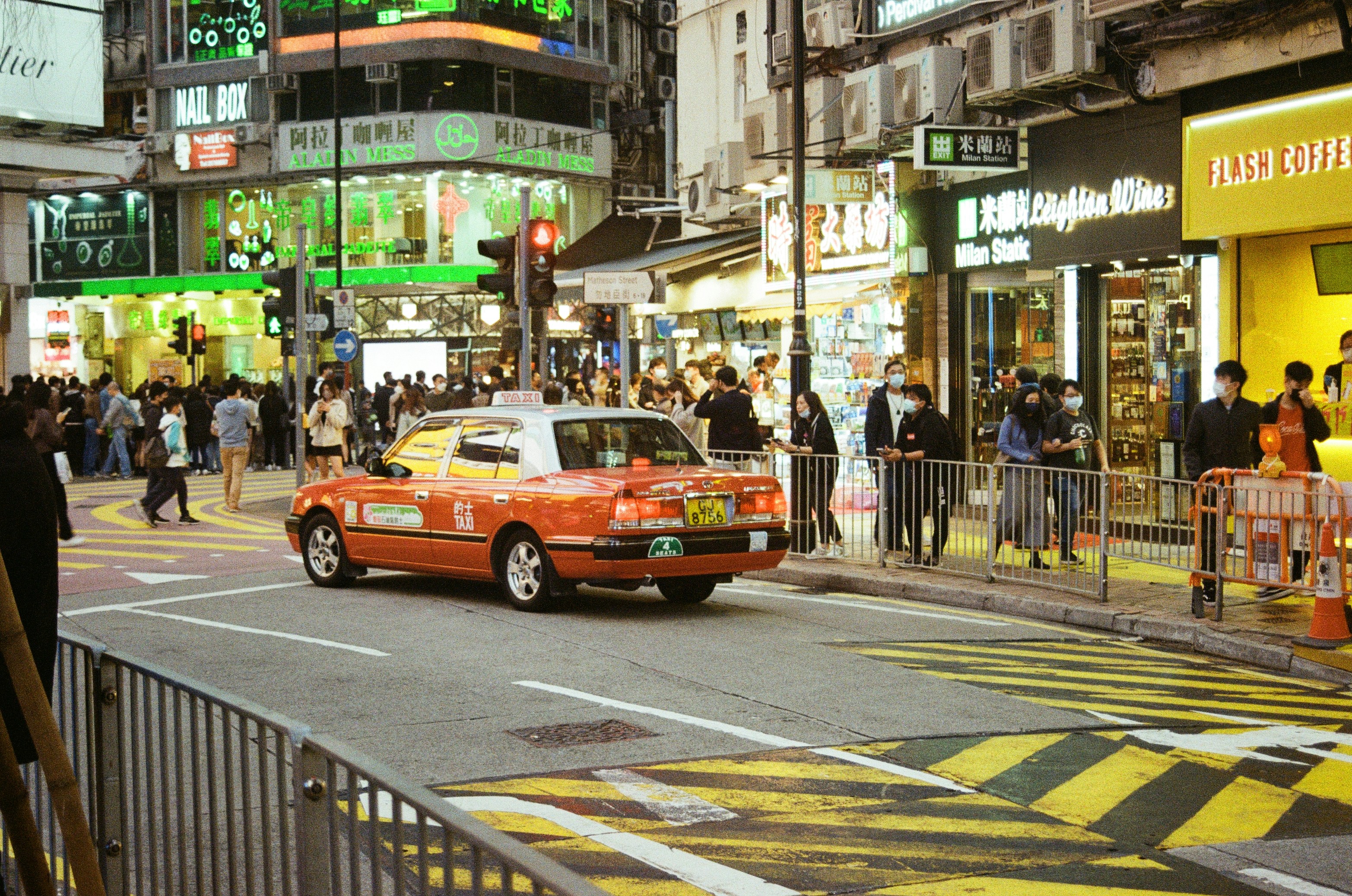 Compact electric hatchback parked on a city street near a charging station