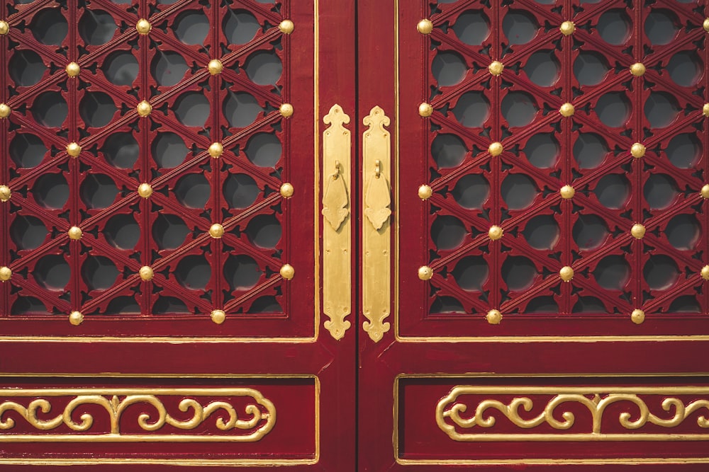 a close up of a red and gold door