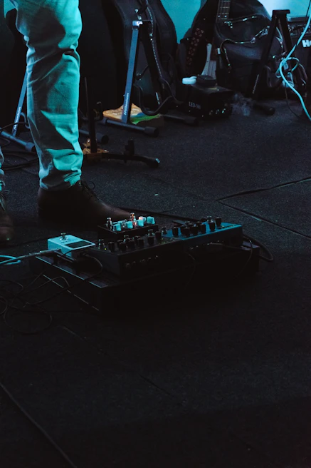 Crowd gathered around a demo booth, watching a musician test out new pedals