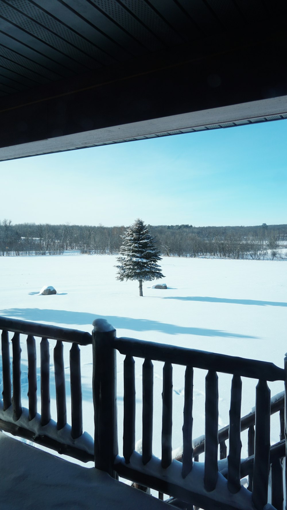 a view of a snow covered field from a porch