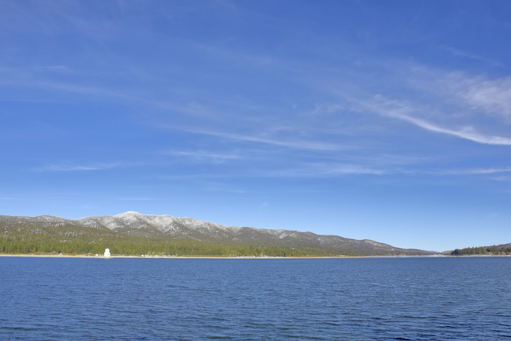 a large body of water with a mountain in the background