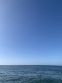 Open waters stretching to the horizon under a clear blue sky, evoking peace and clarity.
