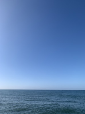 A serene ocean horizon blending into a clear blue sky, inviting endless possibilities.