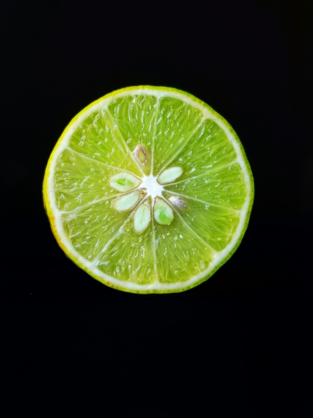a lime cut in half on a black background