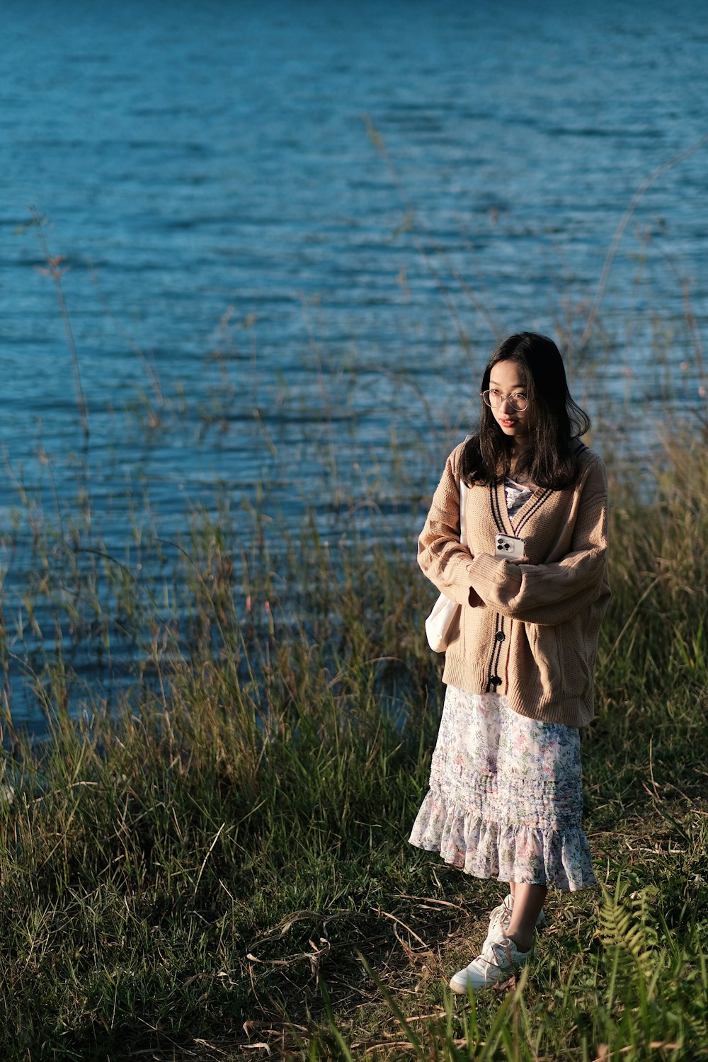 a woman standing in front of a body of water