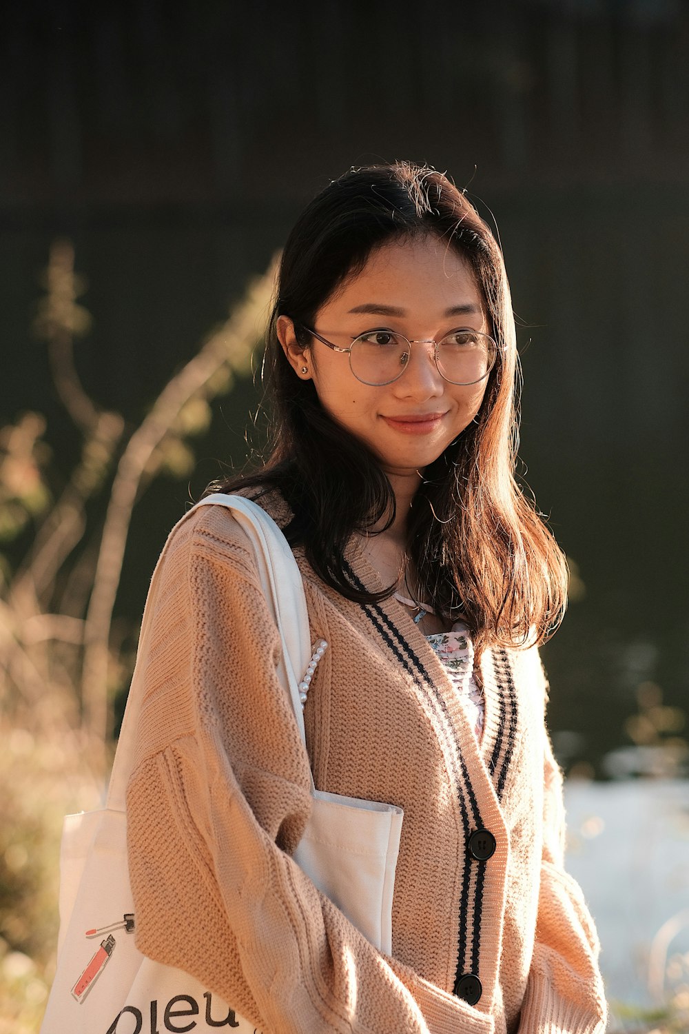 a woman with glasses is holding a shopping bag