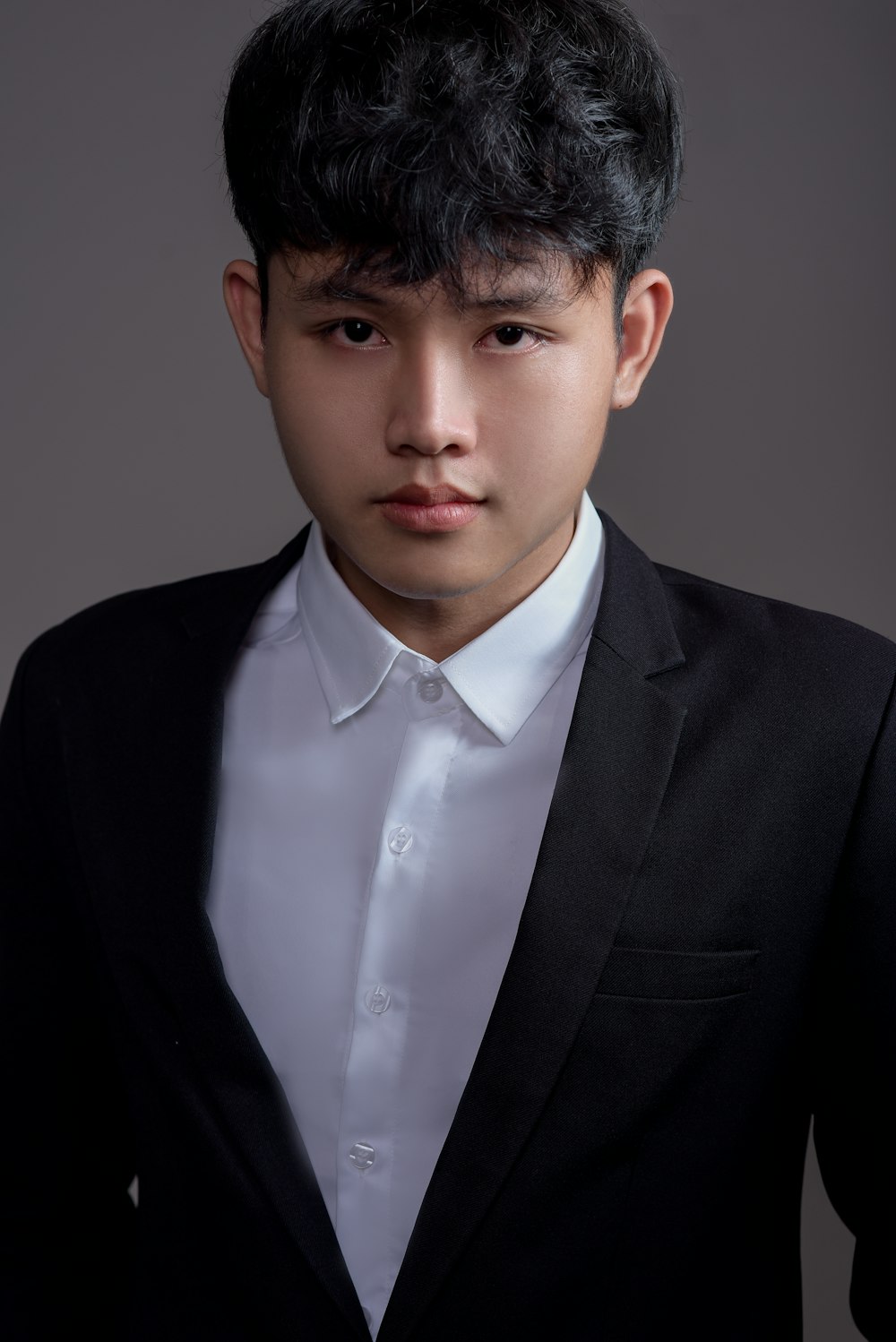 a young man wearing a suit and white shirt