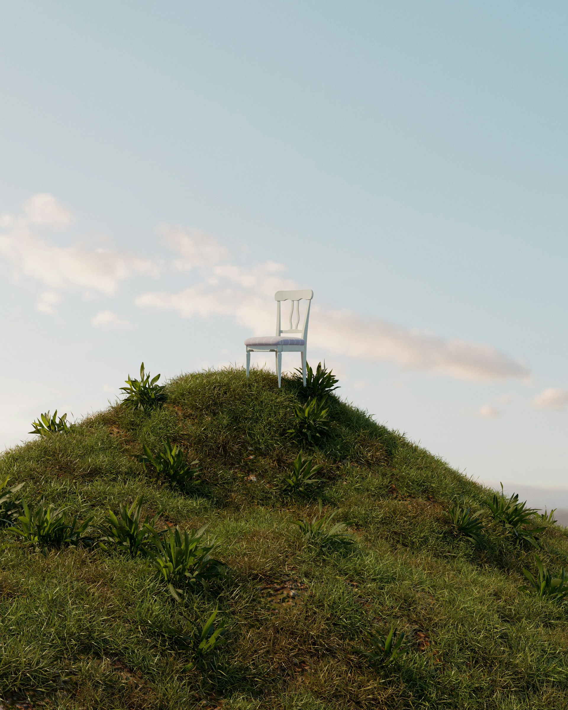 a white chair sitting on top of a grass covered hill