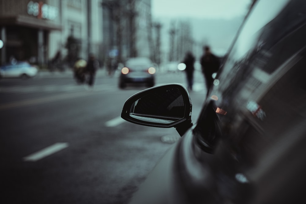 a side view mirror of a car on a city street