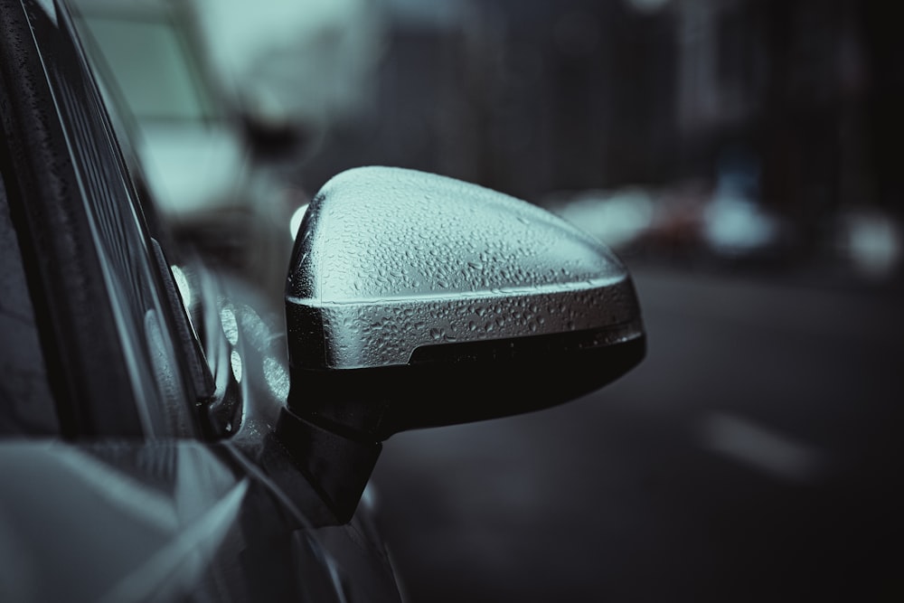 a side view mirror of a car on a city street