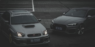 A sleek car and heavy vehicle parked side by side, representing vehicle insurance.