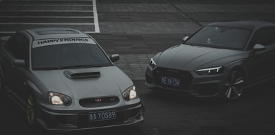 A sleek car and heavy vehicle parked side by side, representing vehicle insurance.