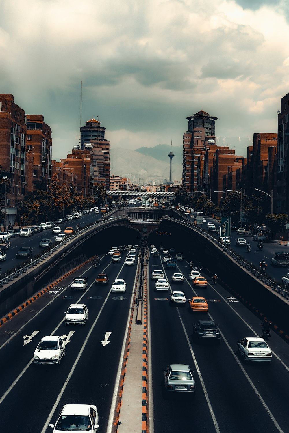 a highway filled with lots of traffic next to tall buildings