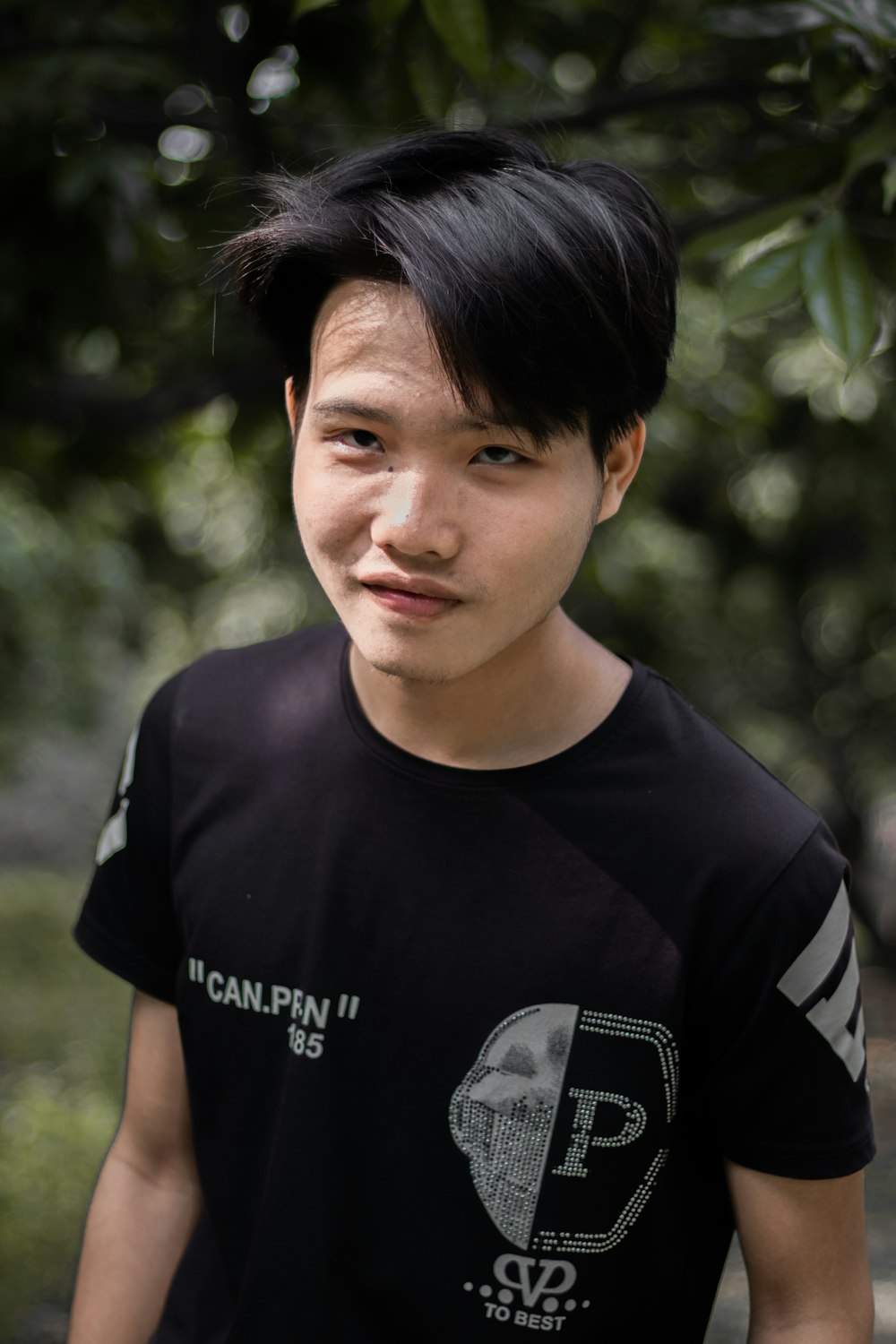 a young man with black hair and a black shirt