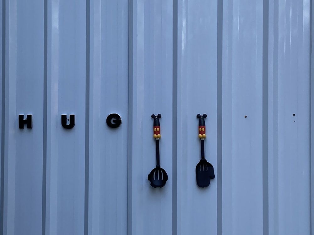 a white wall with three different types of utensils on it