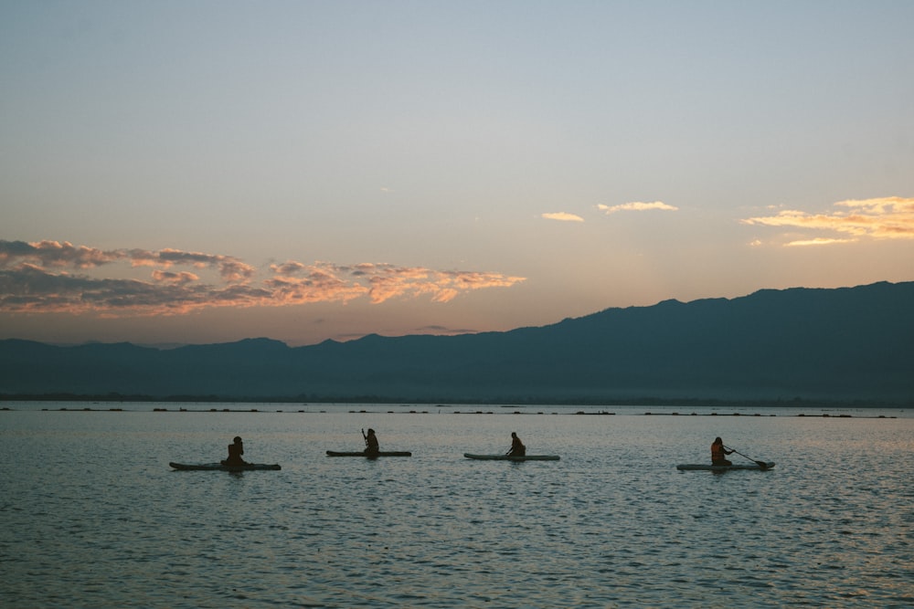 a group of people riding on top of canoes in the water