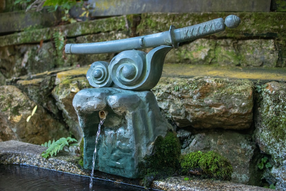 una fontana d'acqua con una statua di un cannone in cima