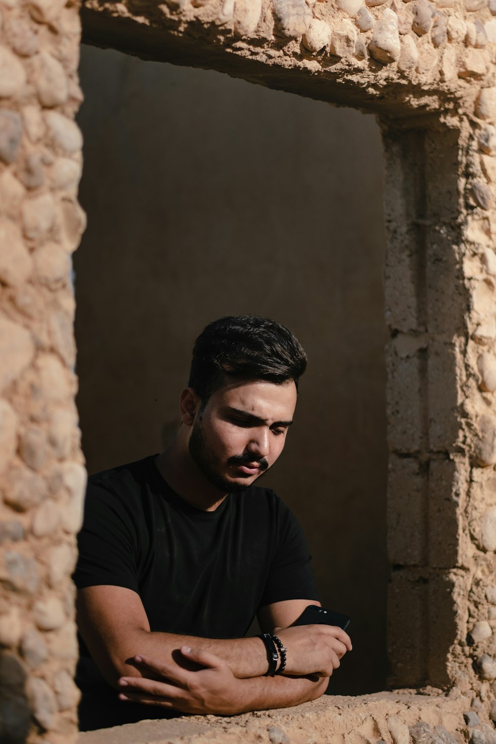 a man sitting in a window of a stone building