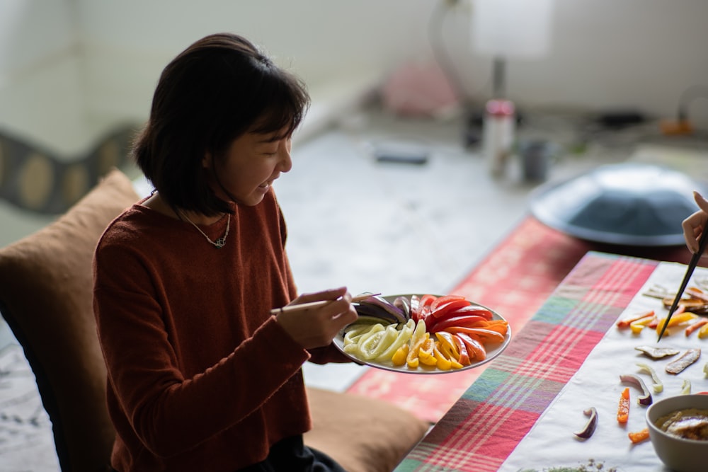 a woman sitting at a table with a plate of food