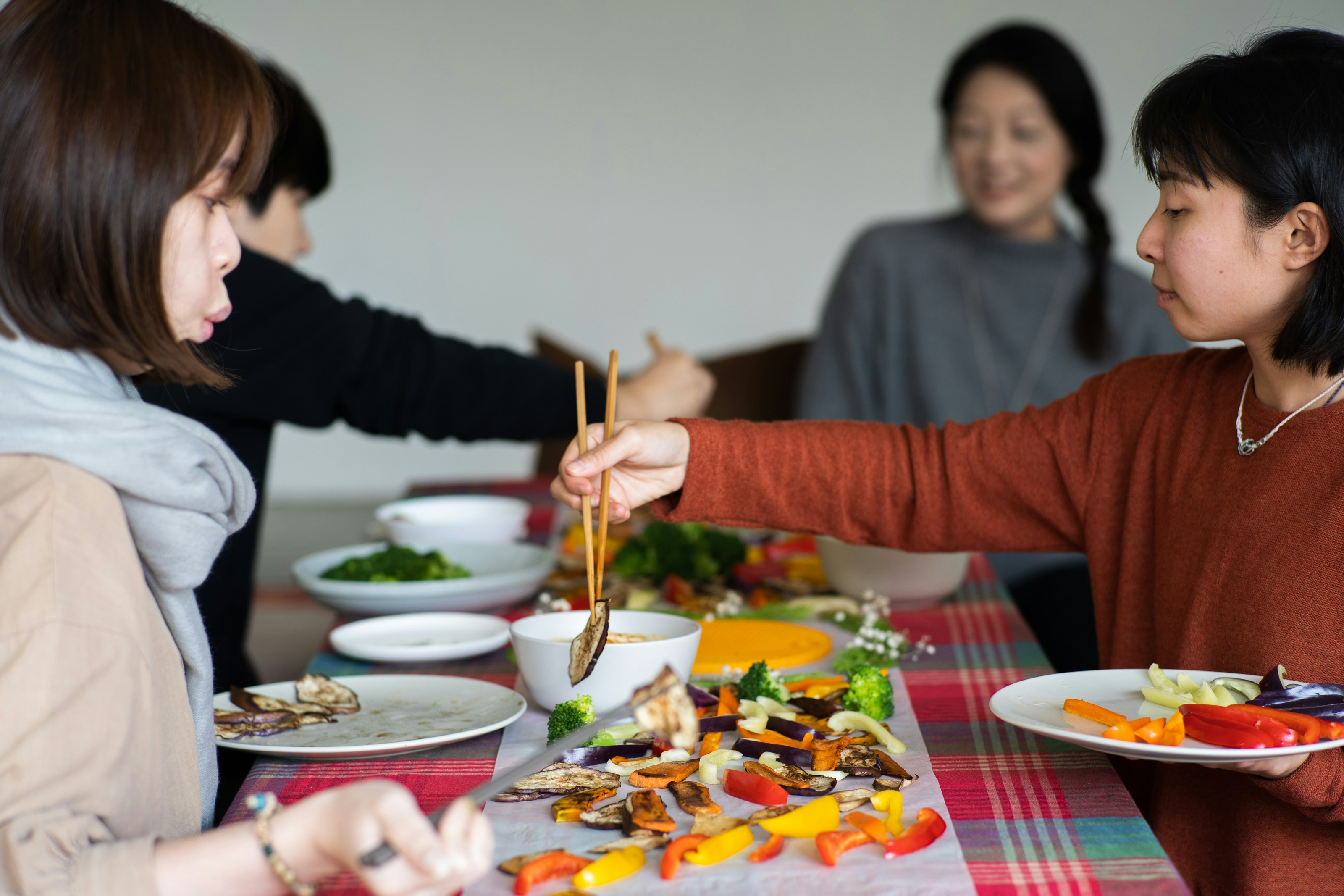 a group of women sitting around a table eating food