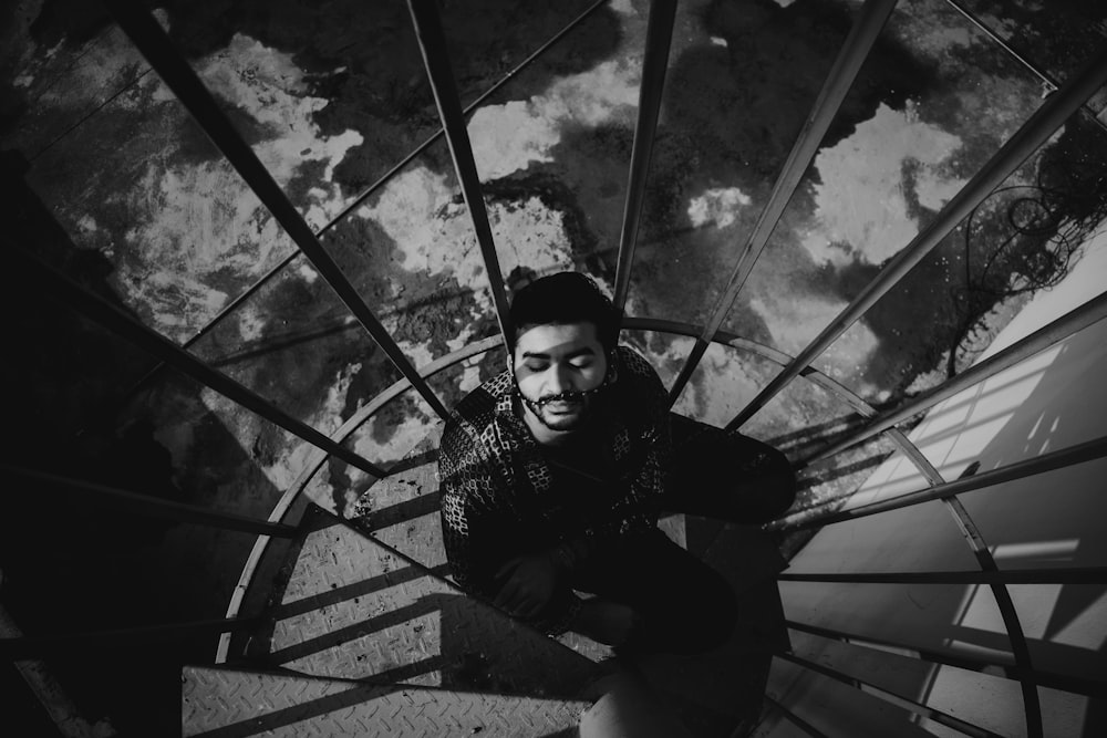 a black and white photo of a man on a staircase