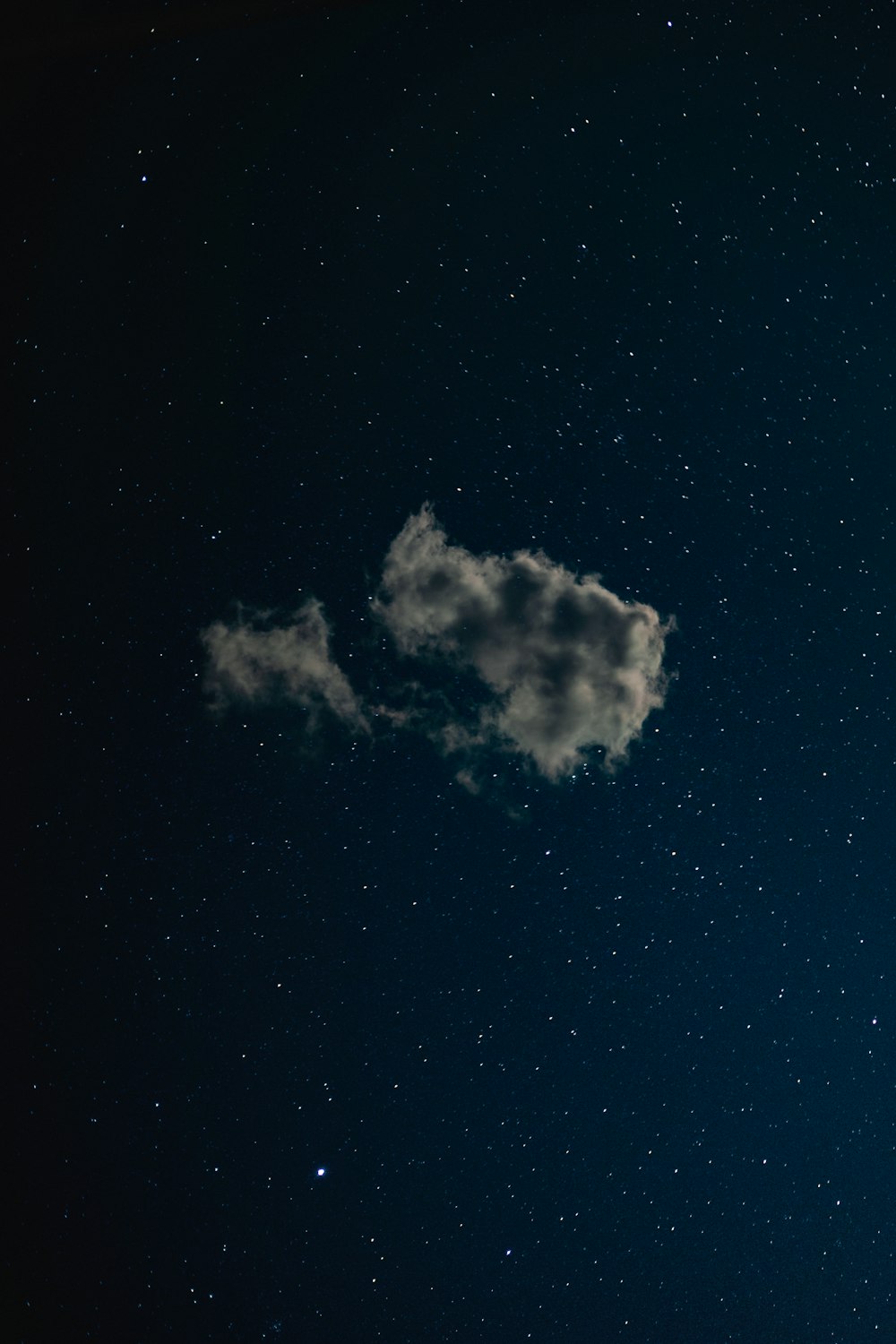 a night sky with stars and a cloud