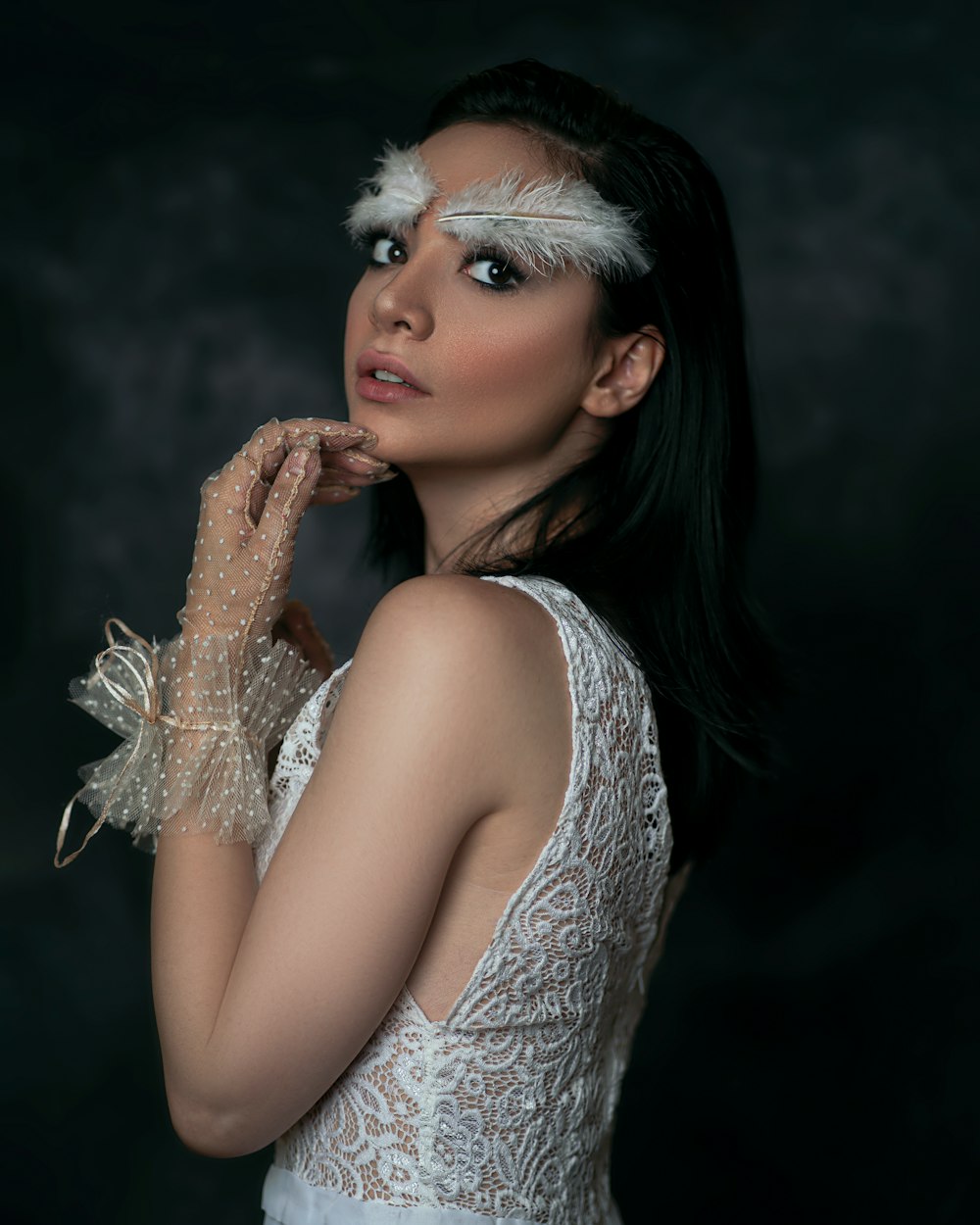 a woman in a white dress with feathers on her head