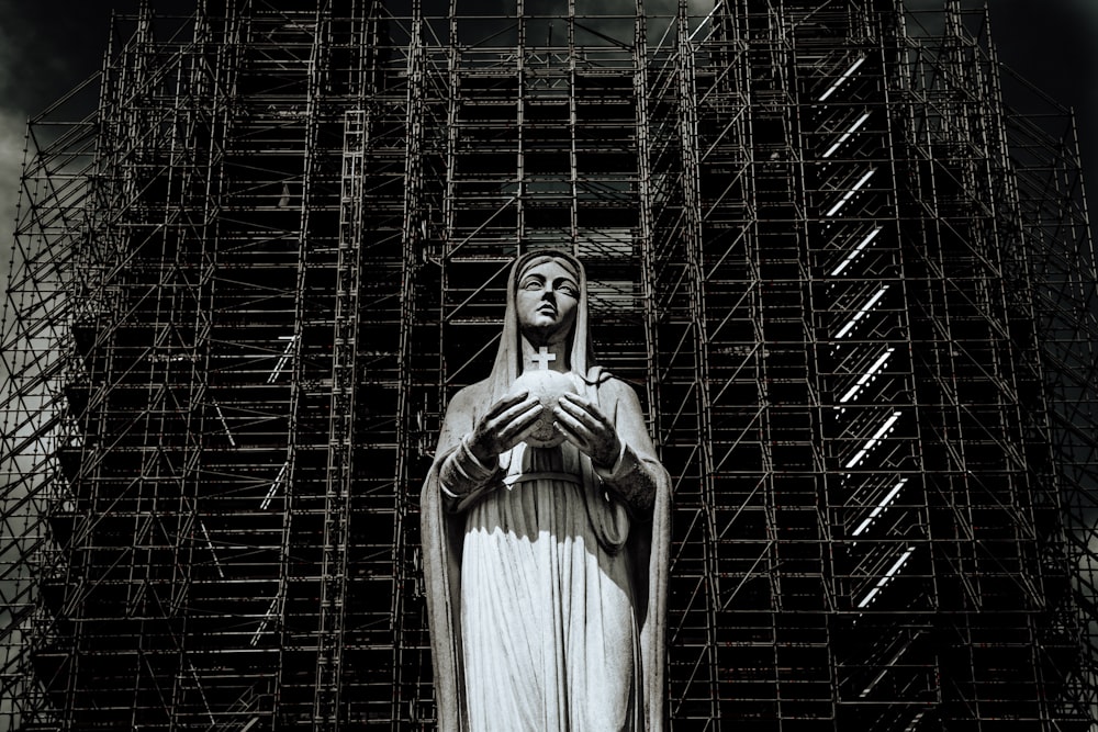 a statue of the virgin mary in front of scaffolding