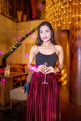 An elegant silhouette of a hostess in black satin, framed by gentle neon lighting.