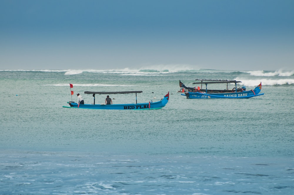 a couple of boats floating on top of a body of water