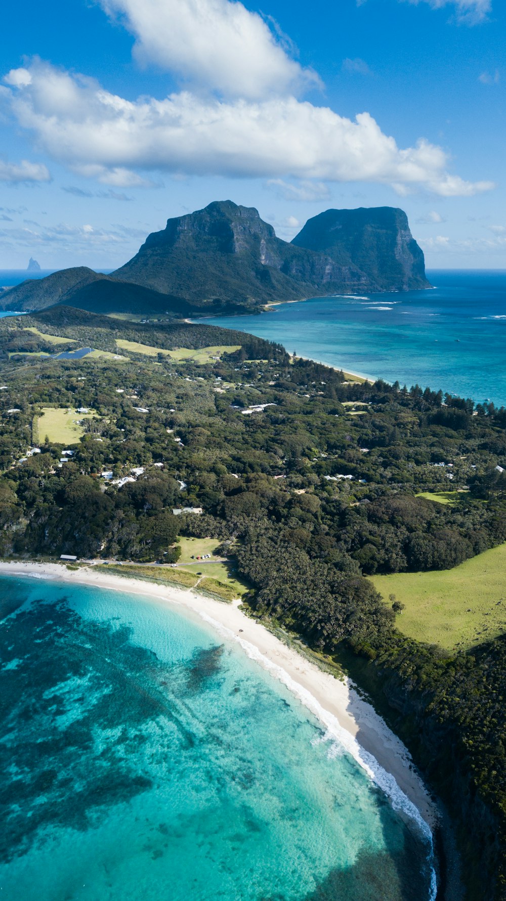 an aerial view of a tropical island with a white sand beach