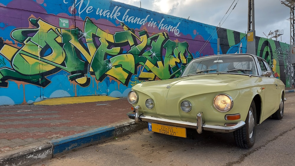 Une voiture garée devant un mur avec des graffitis