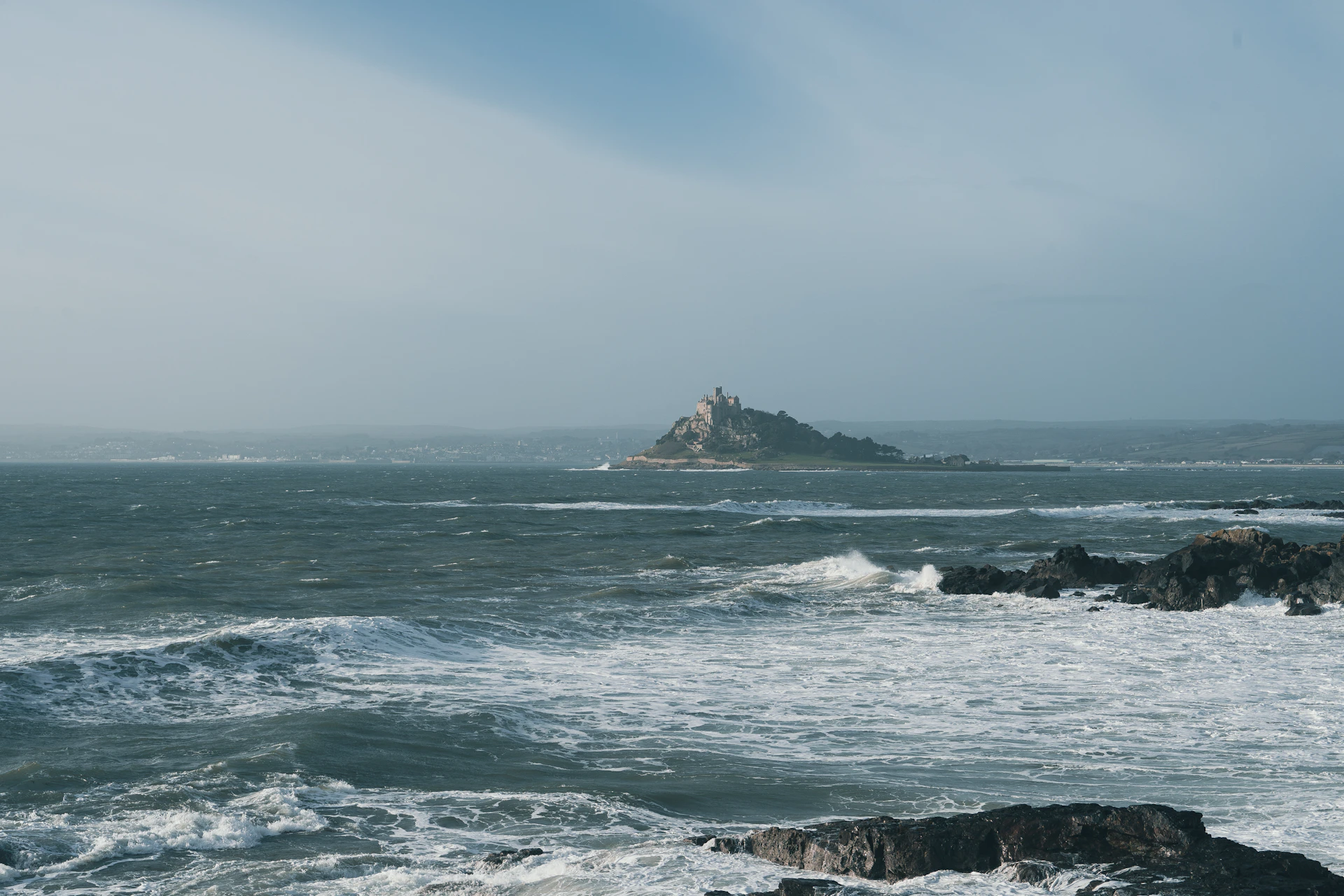 A close-up of the rocky shoreline surrounding Alcatraz, waves crashing as if guarding the island’s secrets.