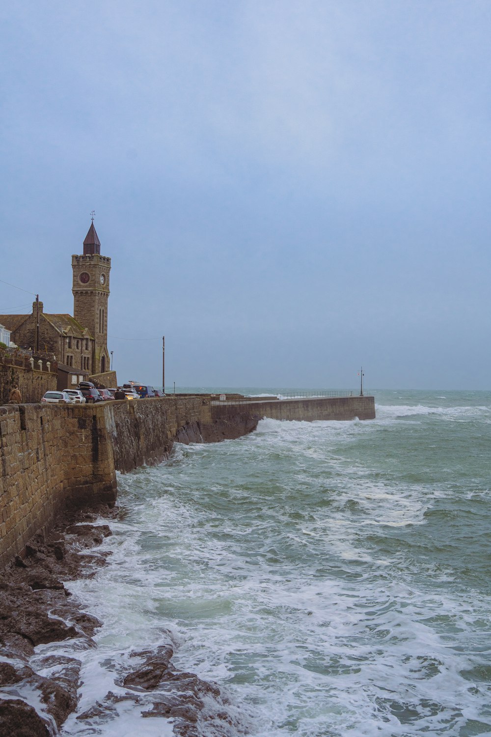 a large body of water next to a stone wall