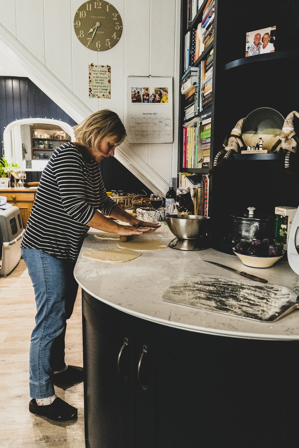 a woman standing in a kitchen preparing food