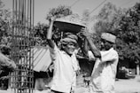two men carrying a basket on their shoulders