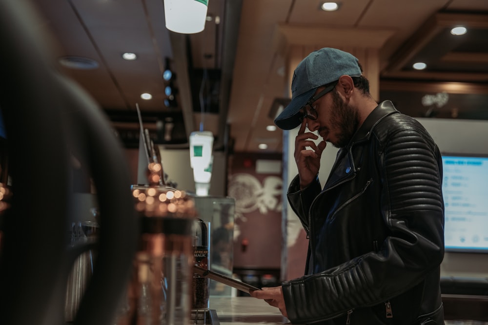 a man in a leather jacket talking on a cell phone