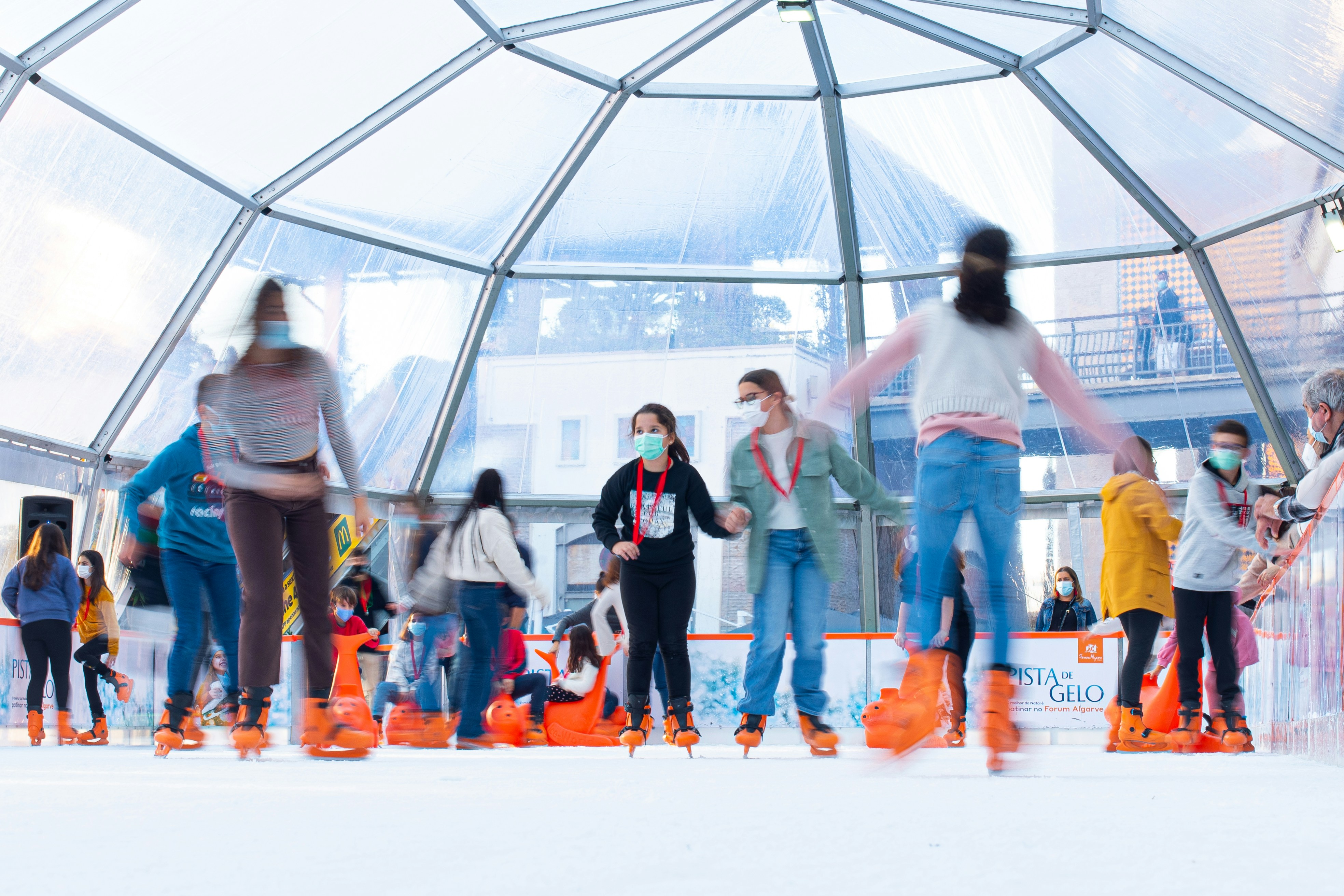 um grupo de pessoas andando de patins em uma superfície nevada