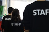 a group of people in black shirts standing in a room