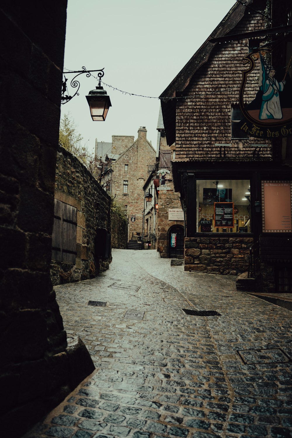 a cobblestone street with a light hanging over it