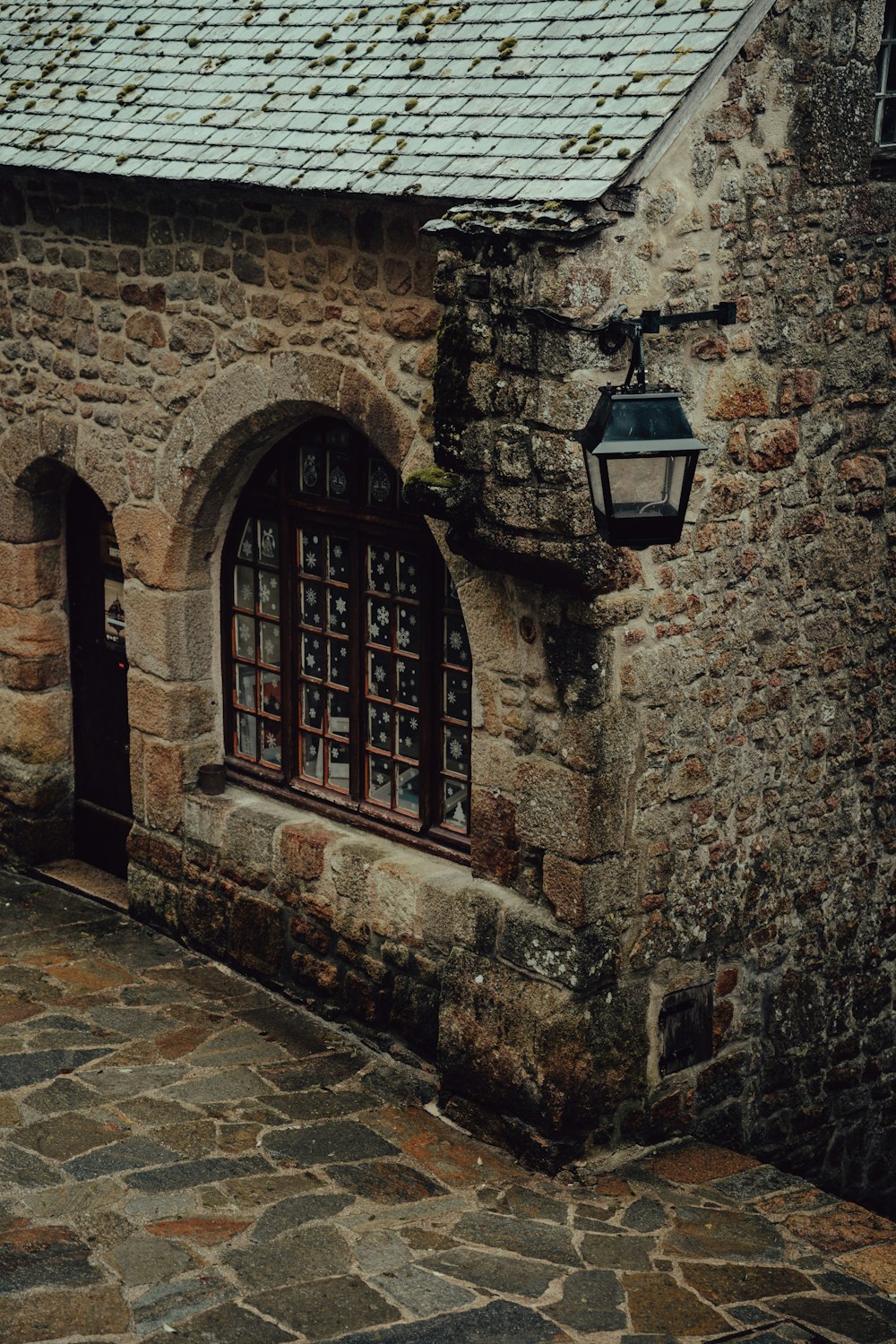 a stone building with a light on the side of it