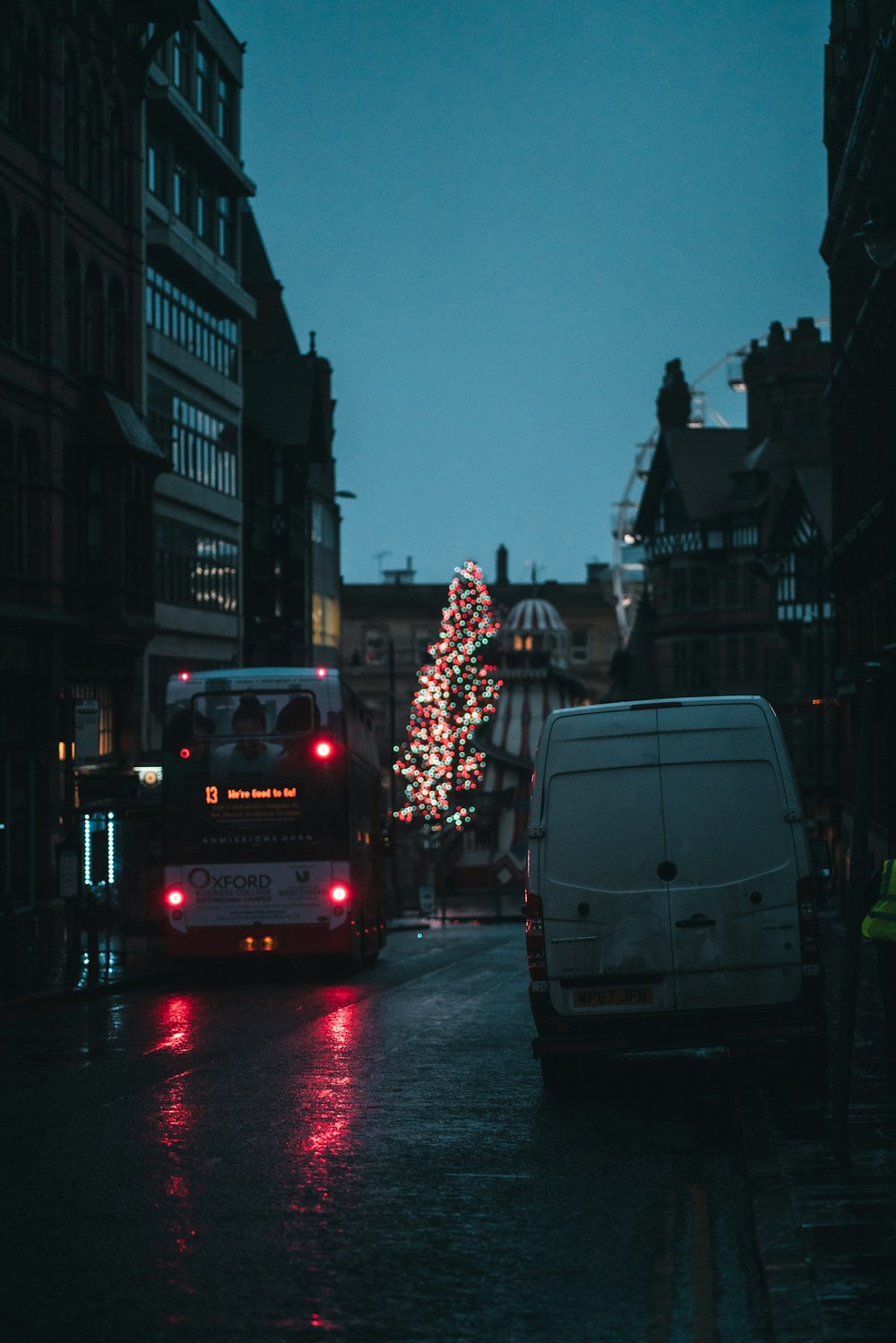a bus driving down a street next to a christmas tree