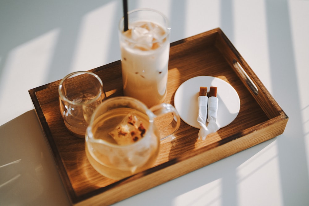 a tray with two glasses and a plate with a drink on it