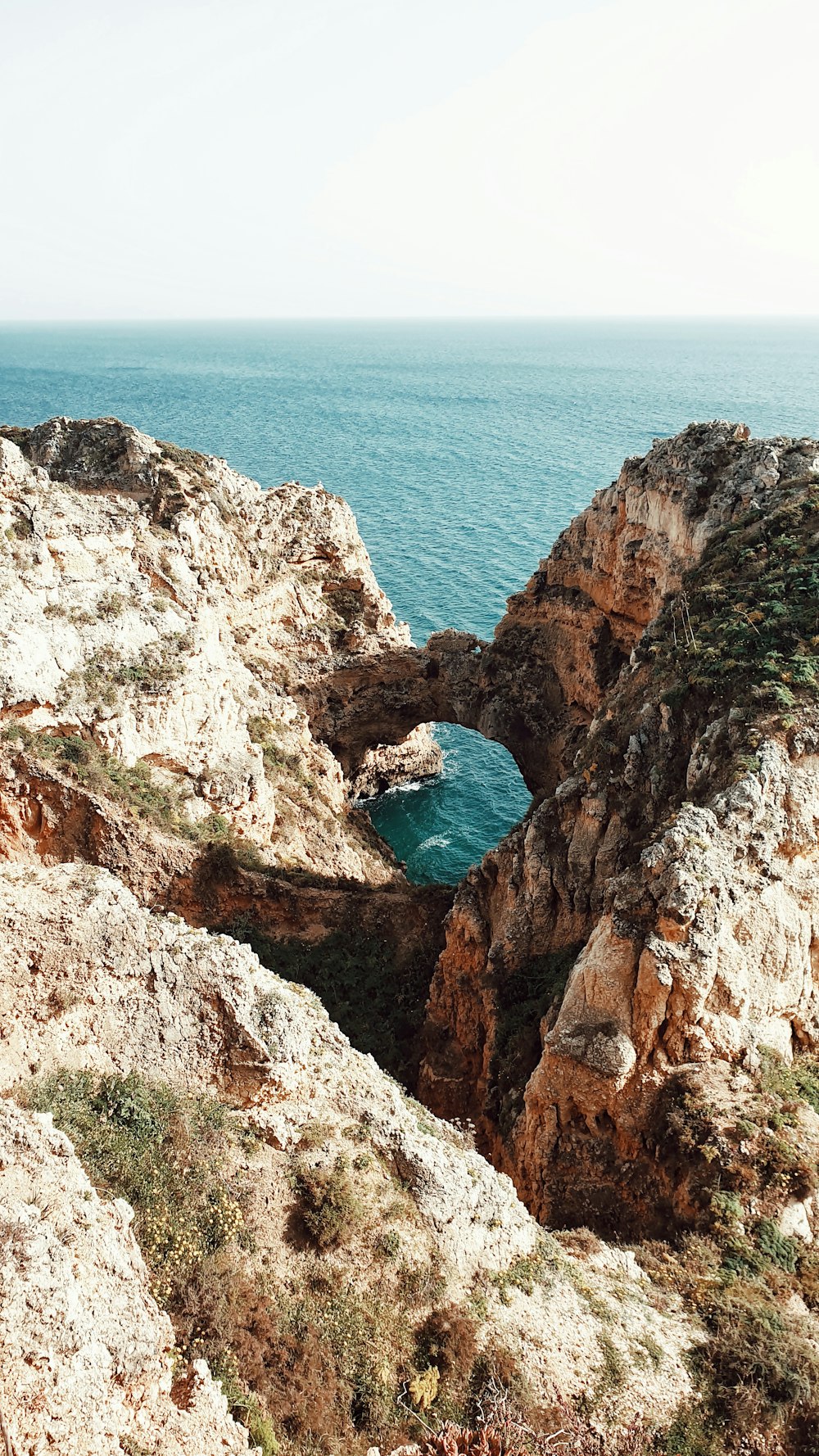 a rocky cliff overlooks a body of water