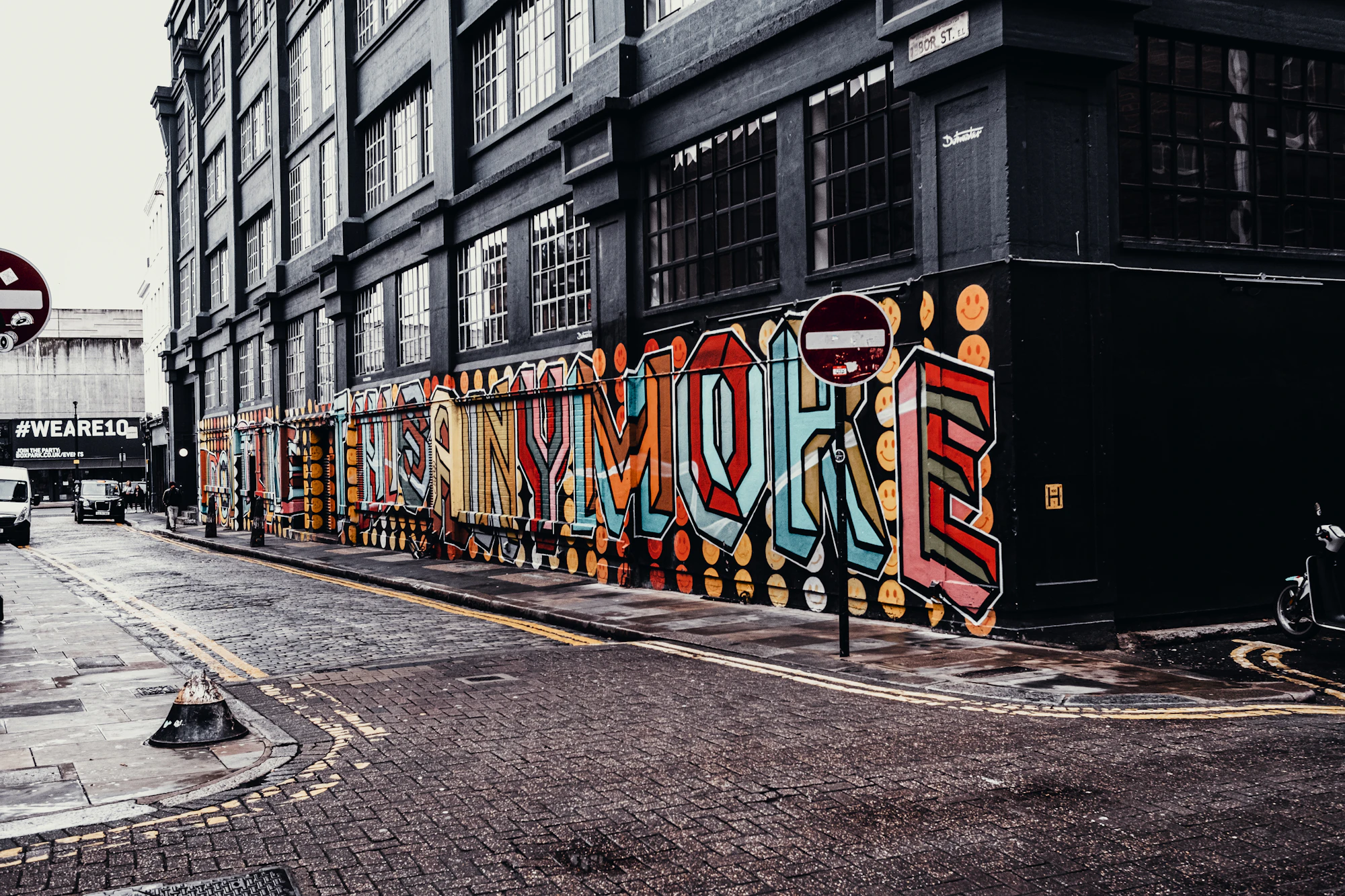 A cobbled Shoreditch street lined with warehouse buildings and street art