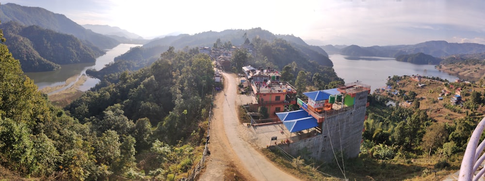 a scenic view of a mountain town with a lake in the background