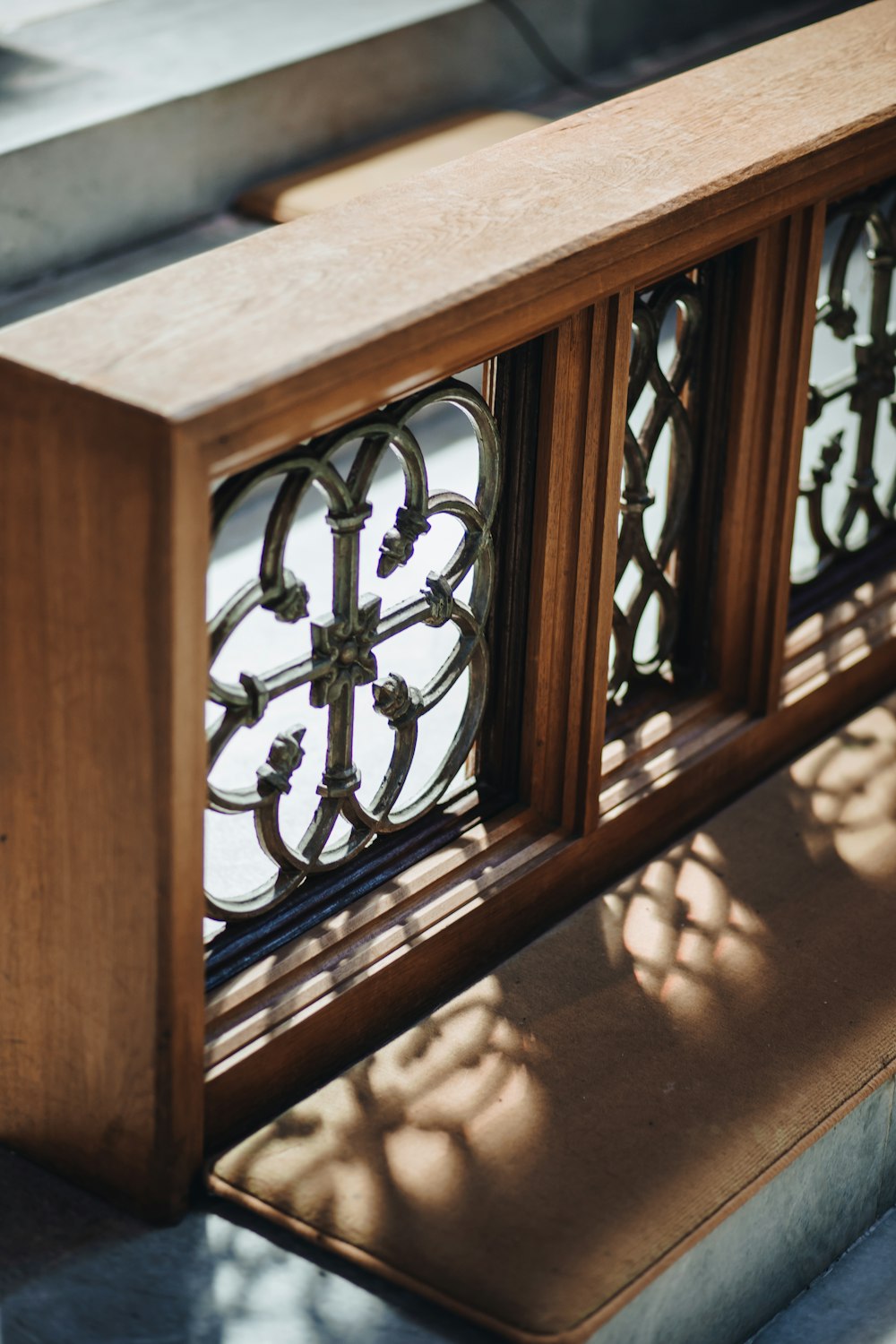 a close up of a wooden bench near a window