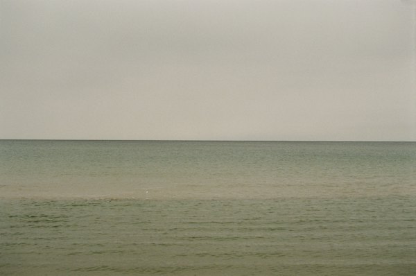 A large body of water sitting under a cloudy sky — Curonian Spit, Lithuania