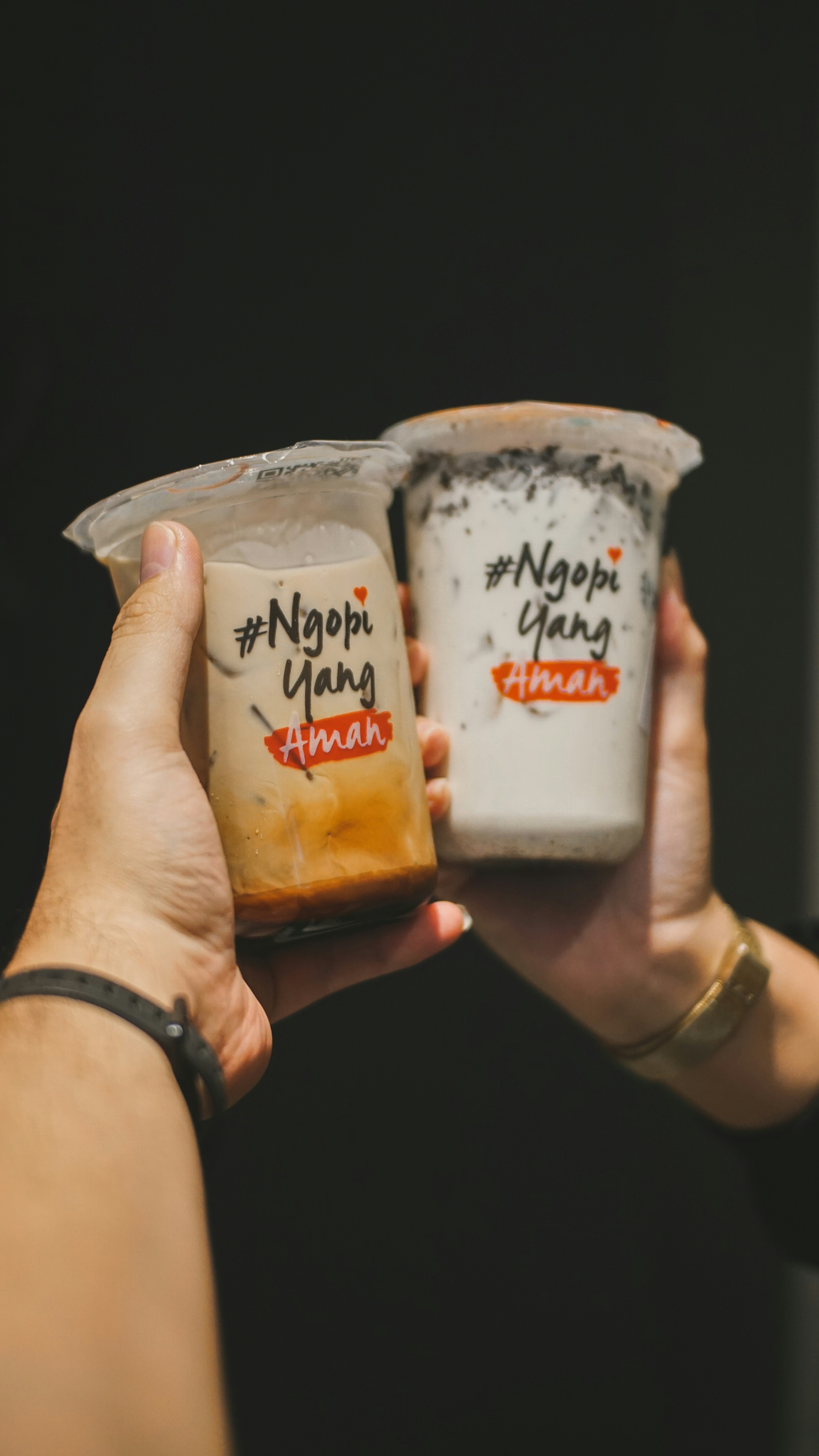 Zwei Personen halten zwei Tassen Joghurt hoch