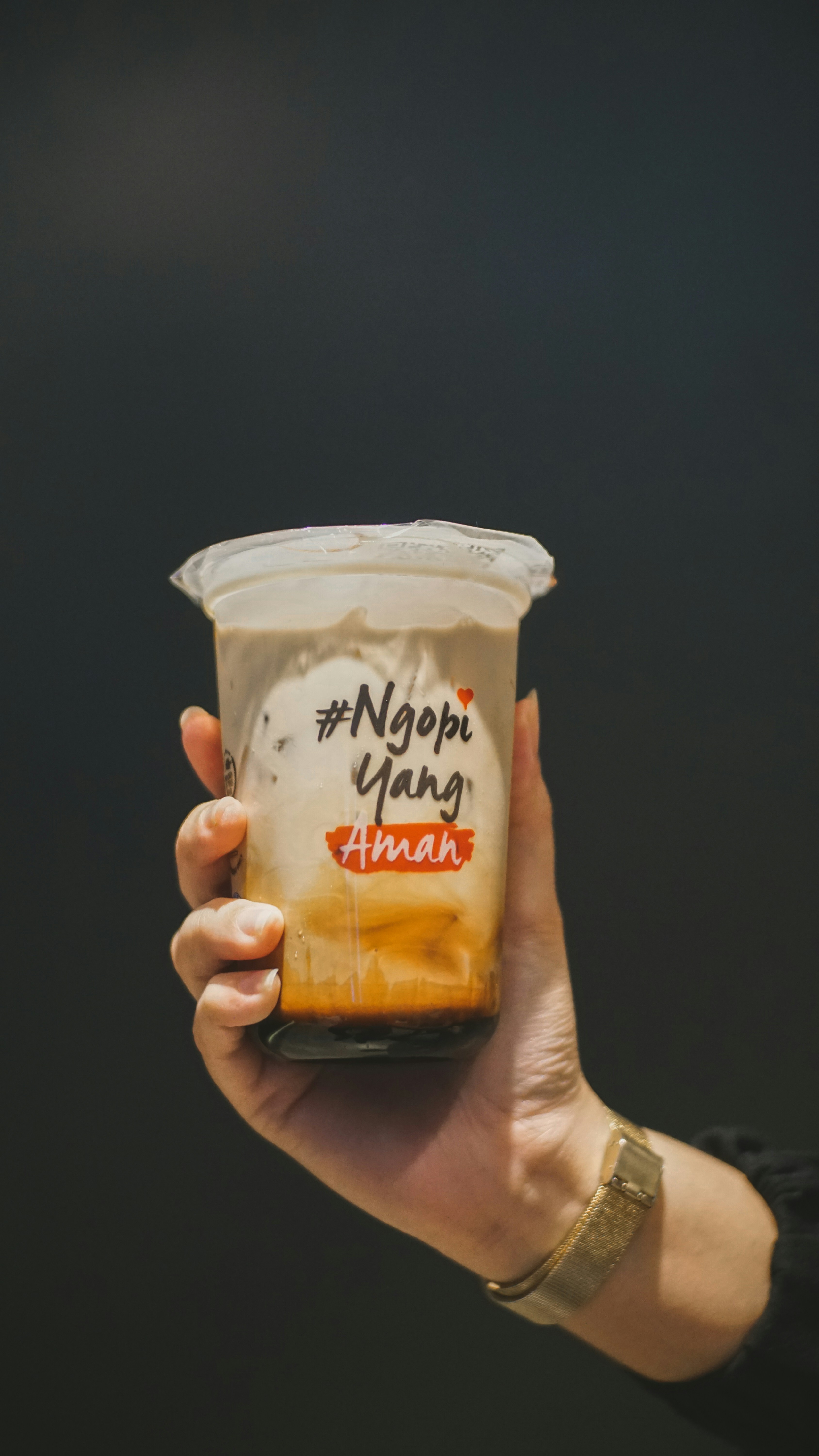 eine Person, die eine Tasse Kaffee hochhält